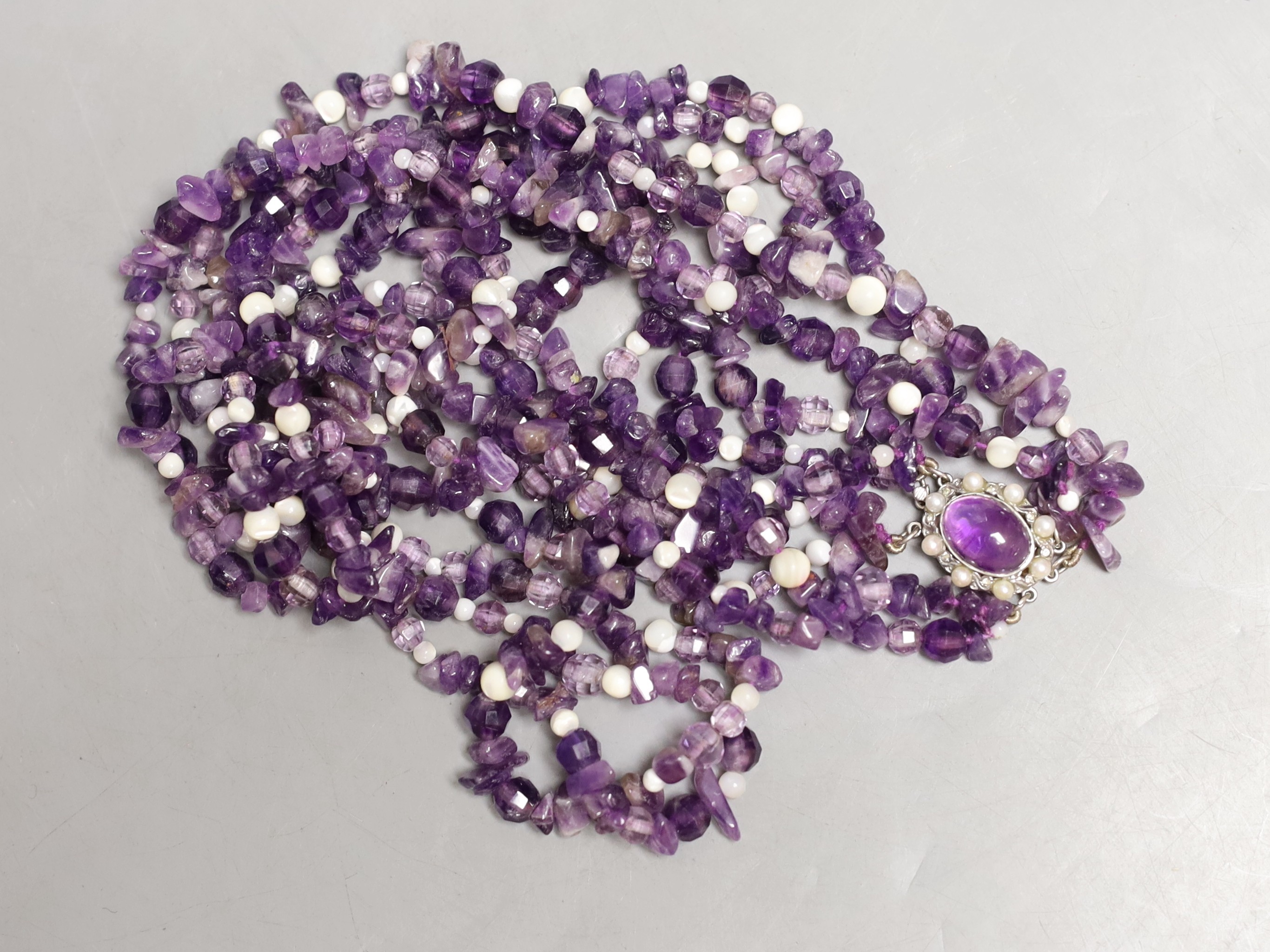 A quadruple strand amethyst pebble necklace, with white bead spacers and white metal clasp, 50cm